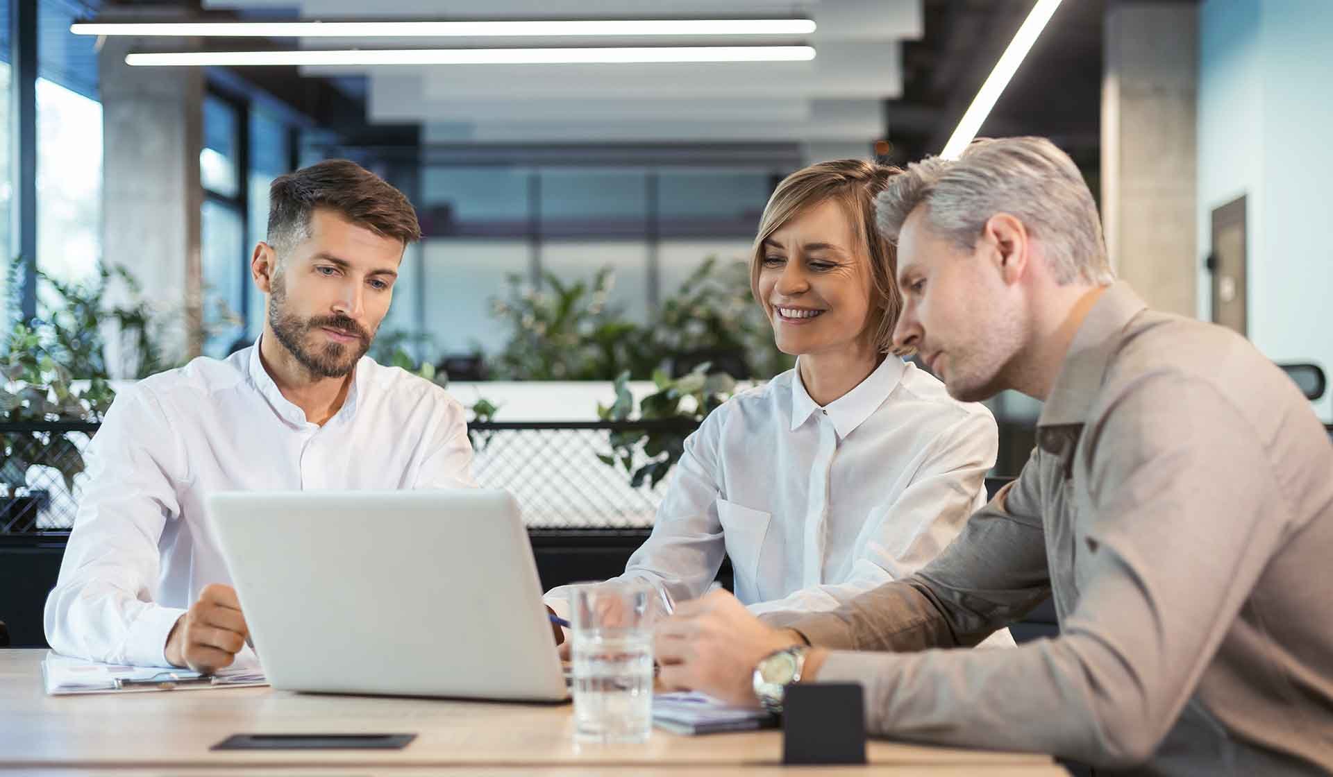 Drei Fachkräfte bei der Besprechung am Laptop – Symbolbild für die Abstimmung von Kalkulation und Baubetriebsrechnung im Bauunternehmen