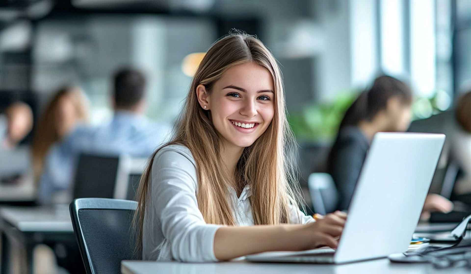 Junge Frau im modernen Büro am Laptop – Sinnbild für Wachstum durch Outsourcing im Baubetrieb